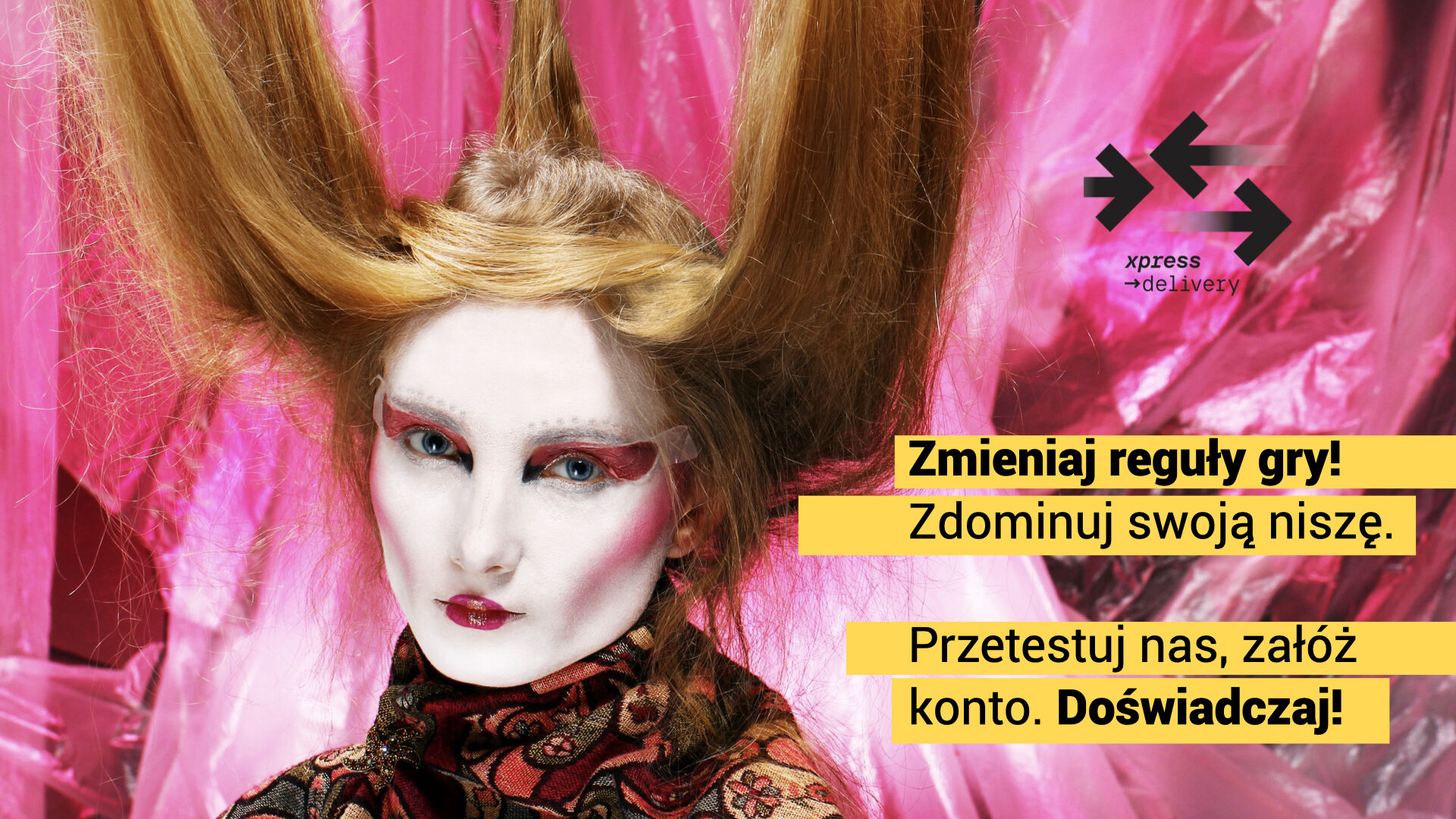 Modelka z teatralnym makijażem i ekstrawagancką fryzurą w stylu fantasy pozuje na tle różowej, błyszczącej folii. Po prawej stronie znajdują się hasła marketingowe marki Xpress Delivery: „Zmieniaj reguły gry! Zdominuj swoją niszę. Przetestuj nas, załóż konto. Doświadczaj!” oraz logo firmy. Całość utrzymana w odważnym, artystycznym stylu wizualnym.