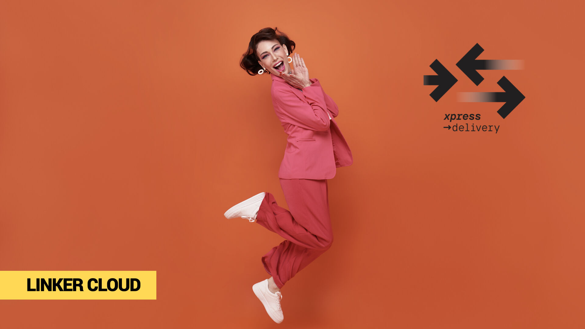 Skacząca kobieta w różowym garniturze na pomarańczowym tle – wizualna metafora szybkości i energii. Branding Linker Cloud i xpress →delivery symbolizuje ekspresowe dostawy w e-commerce i nowoczesne zarządzanie logistyką.