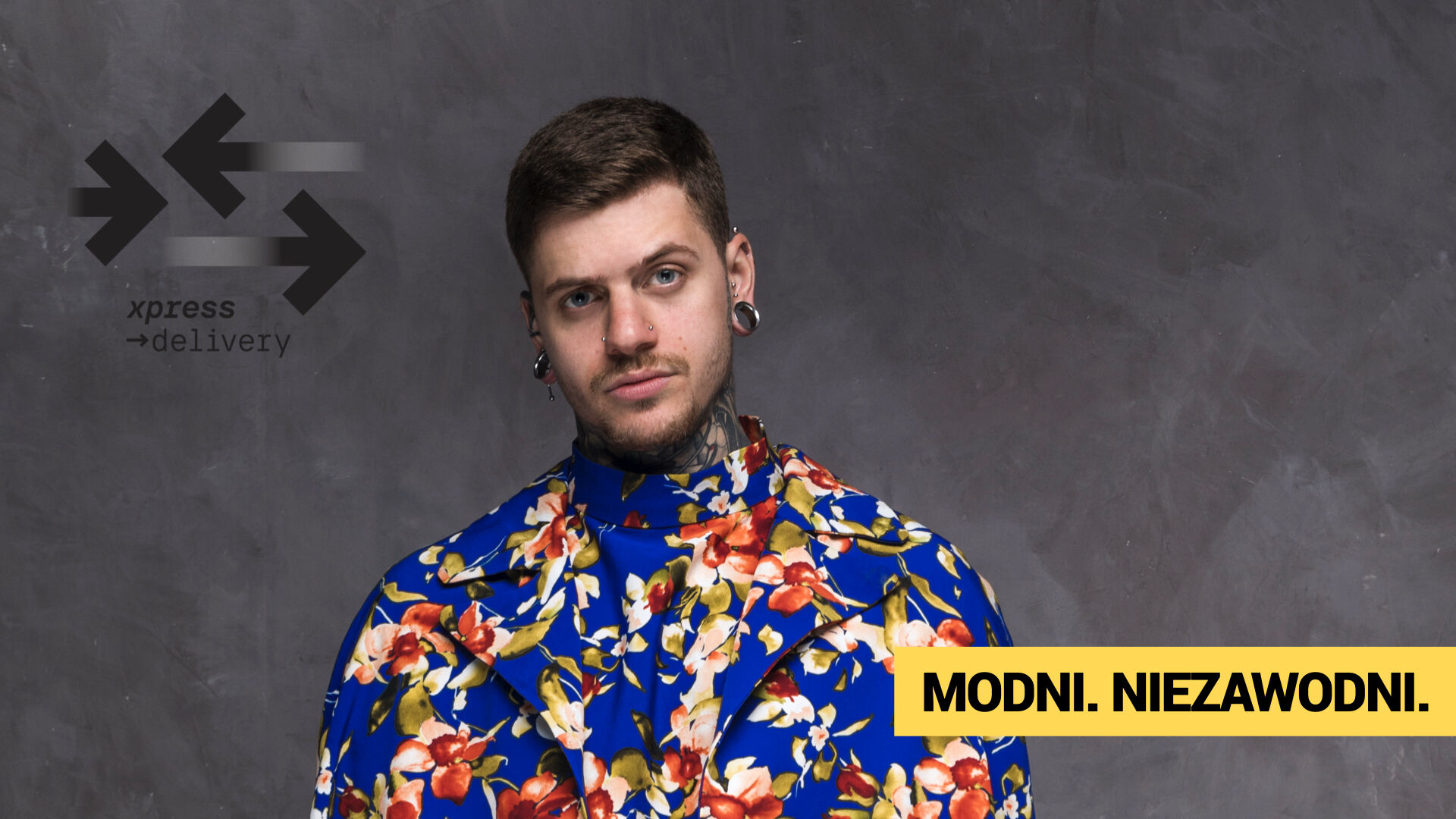 Nowoczesny portret mężczyzny w ekstrawaganckim kwiecistym płaszczu, reprezentujący niezależny styl i branżę fashion. W tle widoczne logo xpress →delivery oraz slogan „MODNI. NIEZAWODNI.” – symbolizujący połączenie trendów mody z szybką, niezawodną dostawą w usługach dla butików i projektantów.